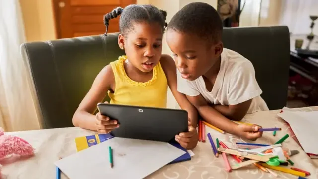 Deux enfants qui apprennent ensemble sur une tablette